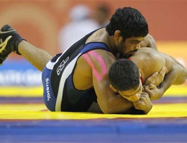 India's Sushil Kumar, in blue, wrestles with Pakistan's Muhammad Salman in their 66kg men's free style wrestling quarterfinals bout during the Commonwealth Games at the Indira Gandhi Sports Complex in New Delhi, India, Sunday, Oct. 10, 2010. (AP Photo/ Eranga Jayawardena)