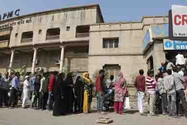 Indians stand in a queue outside a bank to withdraw cash in Ahmadabad, India, Friday, Dec. 2, 2016. A lot of regular activities involving payment in cash is seeing at least a temporary slowdown after Indian Prime Minister Narendra Modi, in his Nov. 8 televised address, announced demonetization of India's 500 and 1,000-rupee notes, which made up 86 percent of the country's currency. People have been forced to stand in long queues to change banned notes and also to take out new currency from their accounts after severe limitations were imposed on withdrawal from banks and ATMs. (AP Photo/Ajit Solanki)