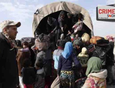 An Iraqi soldier watches while displaced civilians board a truck as Iraqi government forces supported by fighters from the Abbas Brigade, which fight under the umbrella of the Shiite popular mobilisation units, advance in village of Badush some 15 kilometres northwest of Mosul during the ongoing battle to retake the city's west from Islamic State (IS) group jihadists on March 8, 2017. / AFP PHOTO / Mohammed SAWAF