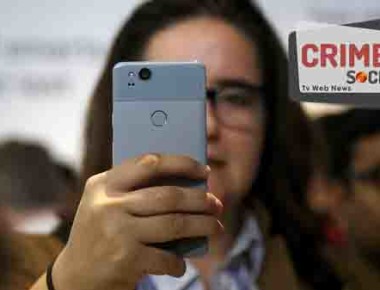 A woman looks at a Google Pixel 2 phone at a Google event at the SFJAZZ Center in San Francisco, Wednesday, Oct. 4, 2017. (AP Photo/Jeff Chiu)