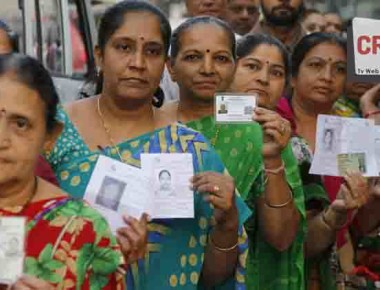 Women display their voter identity cards as they wait to cast their vote during the first phase of the Gujarat state assembly election in Rajkot, India, Saturday, Dec. 9, 2017. Results of the elections will be declared on Dec. 18. (AP Photo/Ajit Solanki)